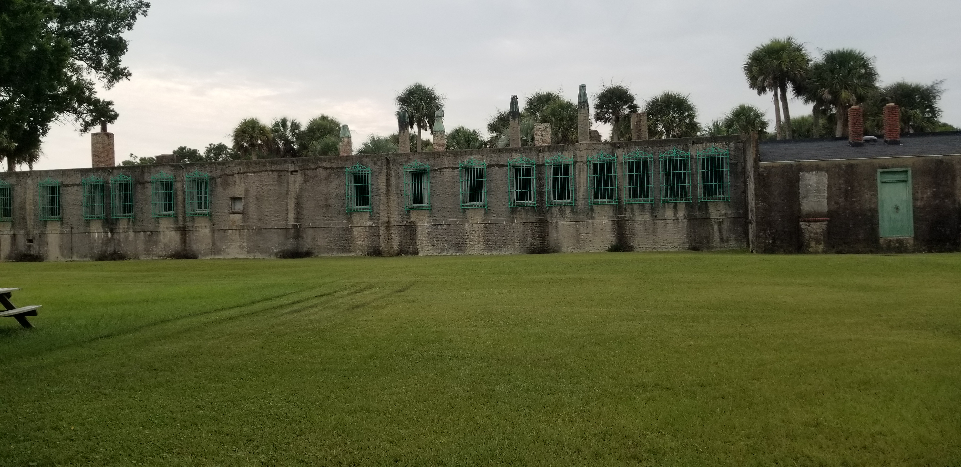 Long brick exterior and green iron windows of Atalaya Castle
