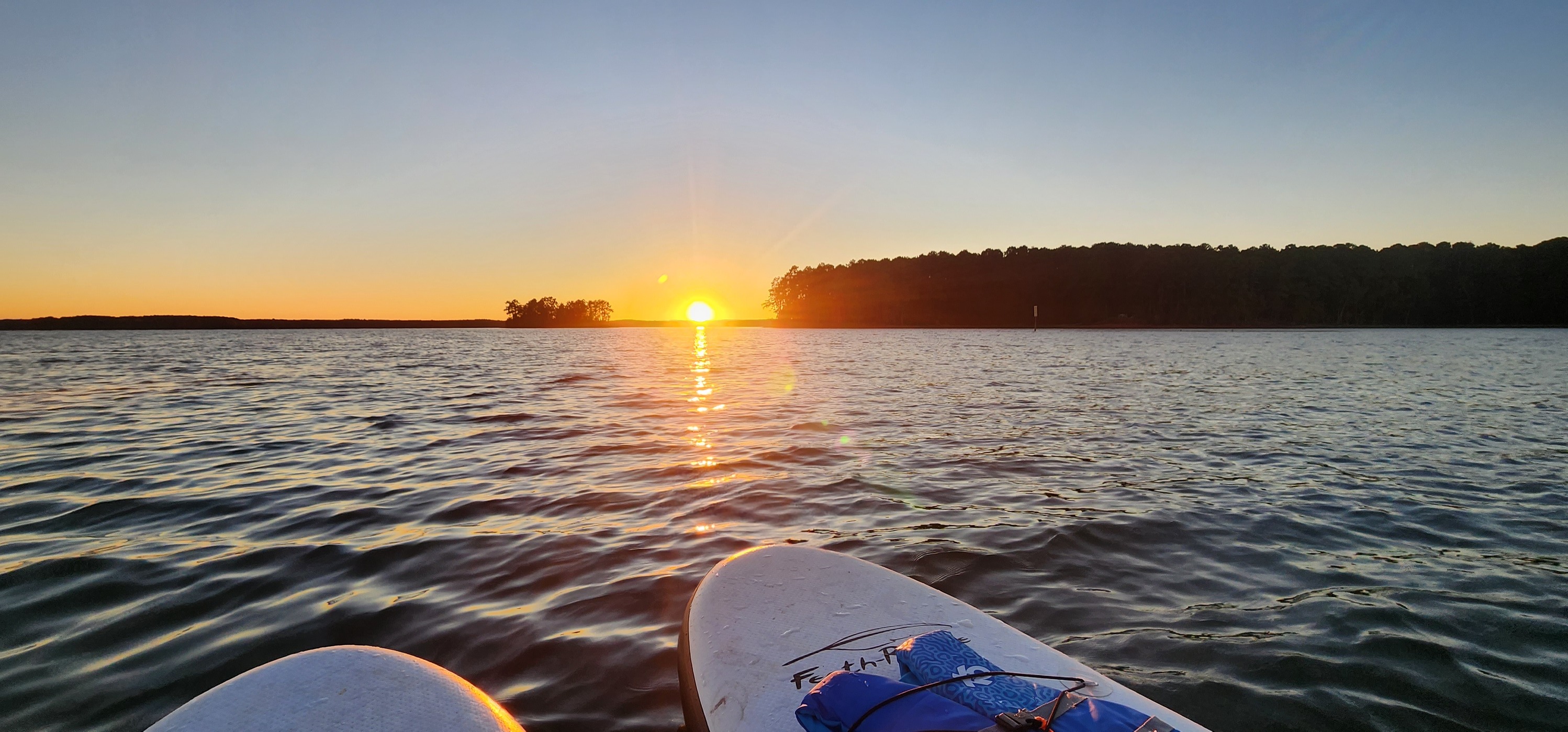 Kayaks facing a golden sunset over Lake Thurmond at Hamilton Branch State Park