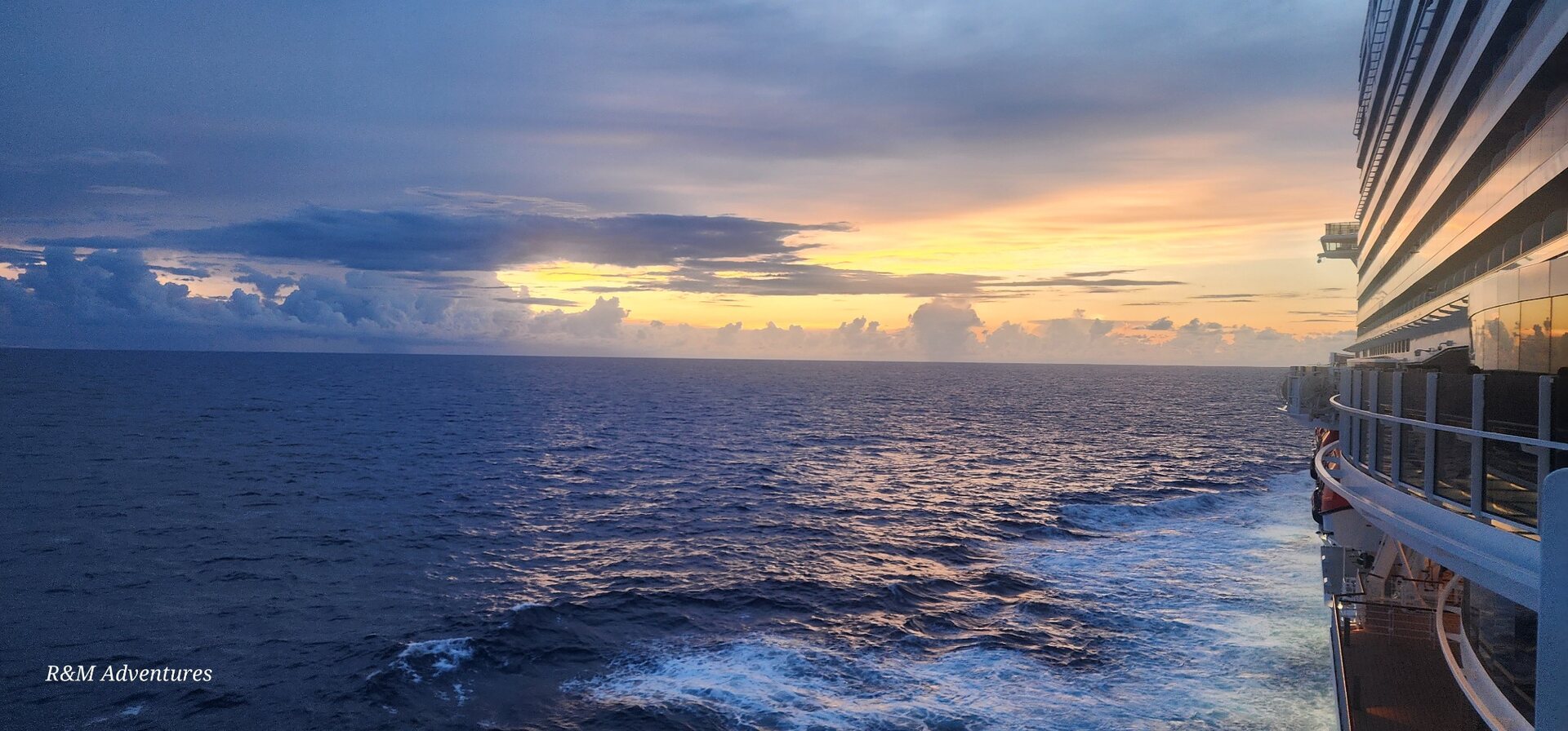 Golden sunset over the ocean beside a cruise ship