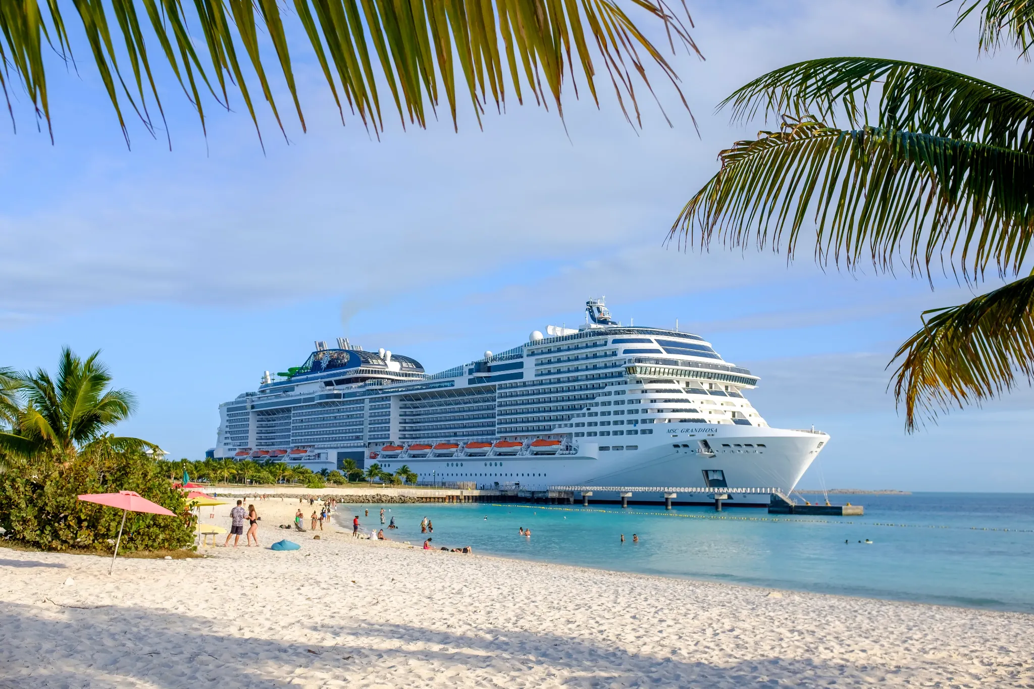 MSC Grandiosa docked beside a tropical beach